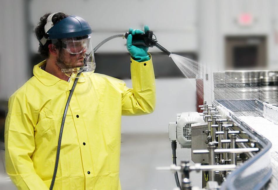 Tailored Industrial Cleaning Solutions – High-Pressure Conveyor Belt Washing Man using high-pressure washer to clean conveyor belt for tailored industrial cleaning solutions